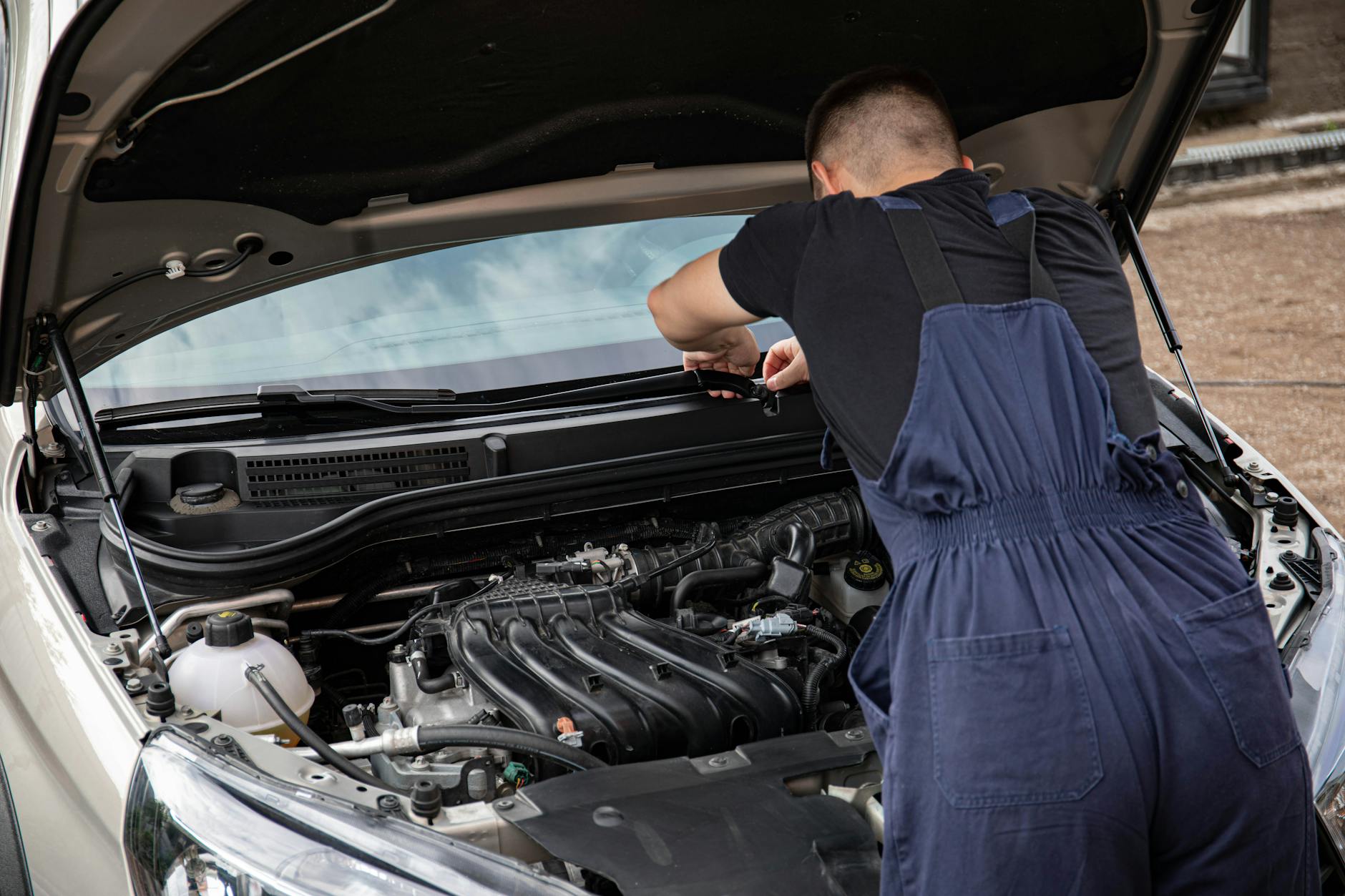 man in black crew neck t shirt fixing a car